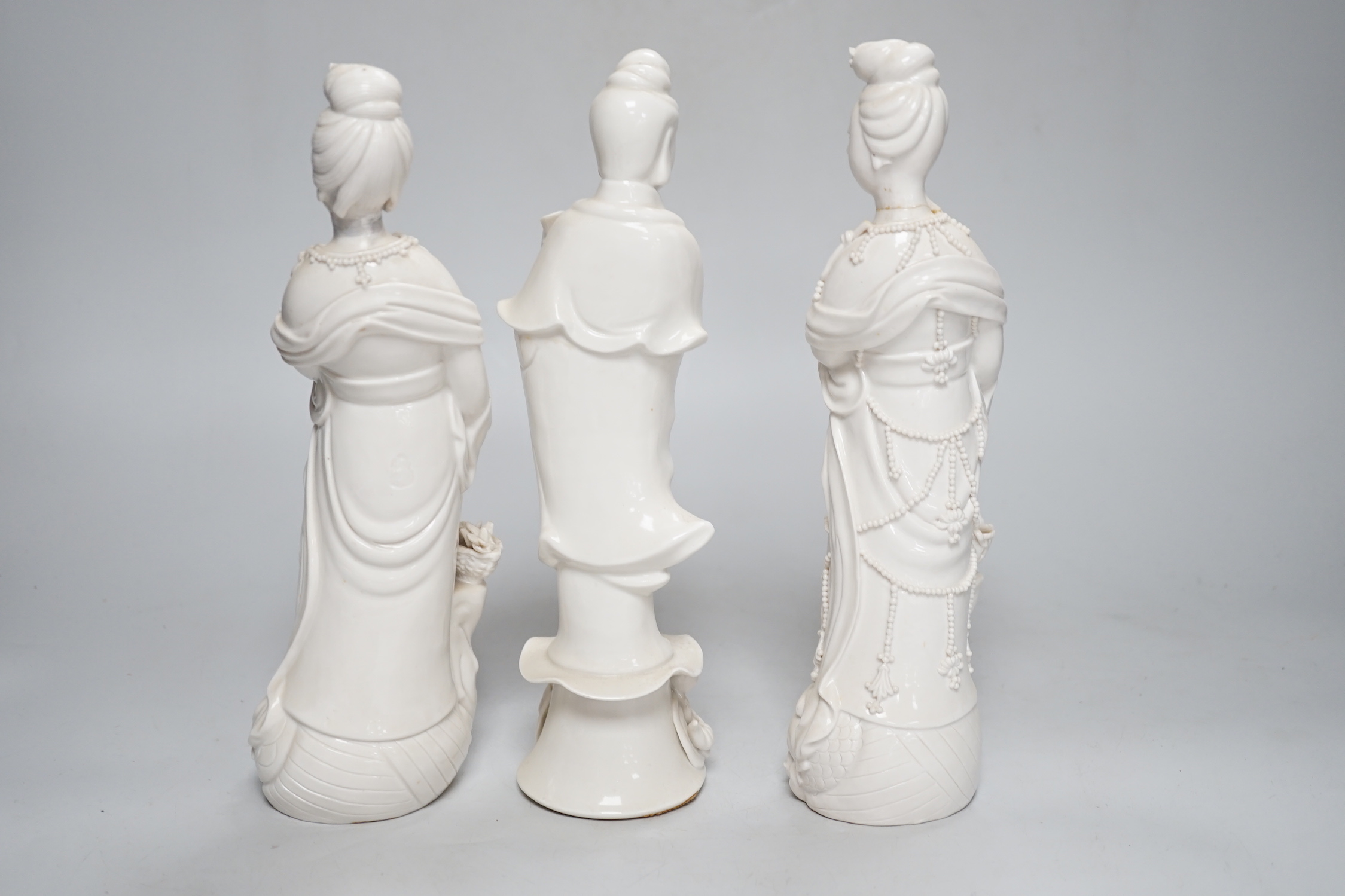 Three Chinese blanc de chine figures of Guanyin, 25cm